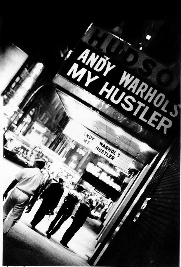 Andy Warhol under My Hustler marquee at the Hudson Cinema, 1967