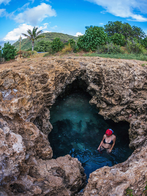 High angle view of a woman bathing in a cave pool in Hawaii, USA.